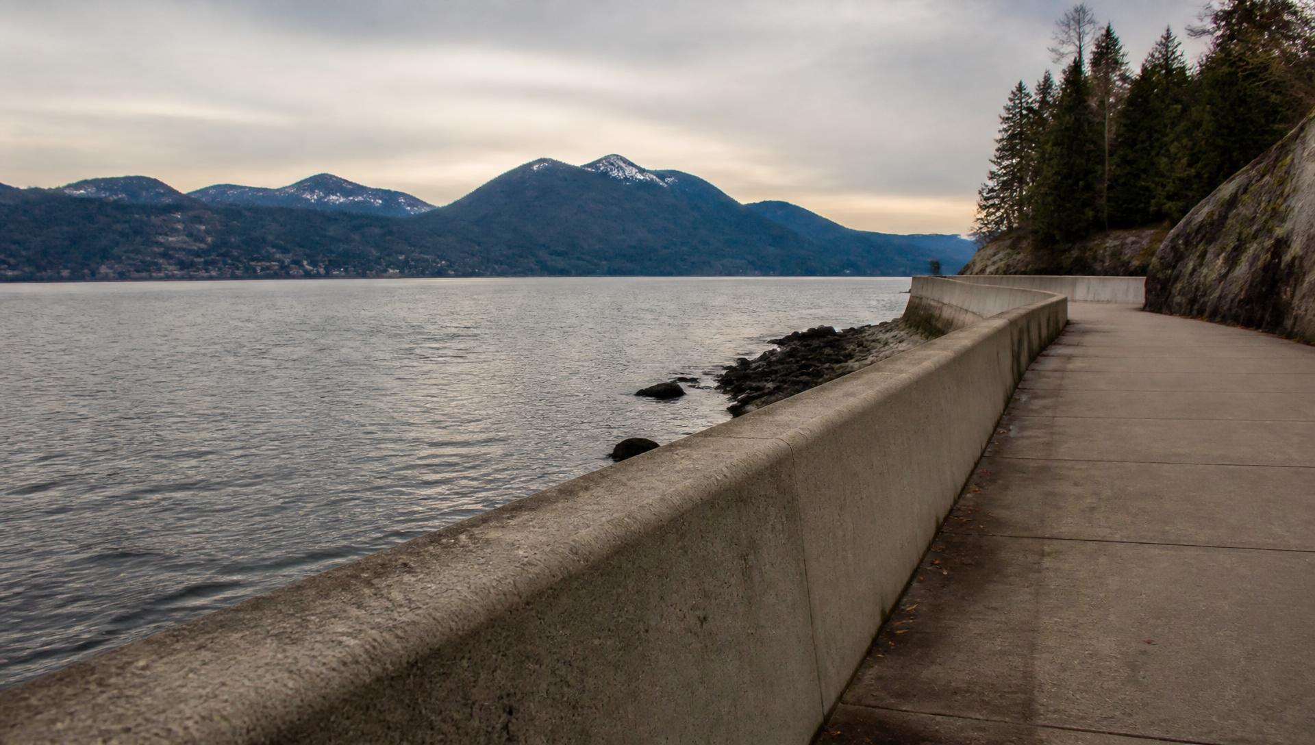 The Ambleside seawall in West Vancouver with the North Shore mountains beyond